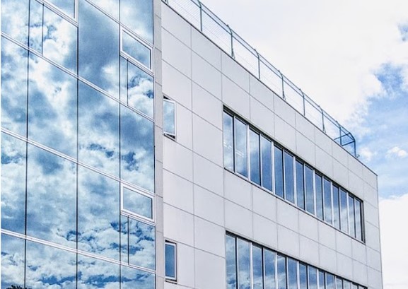 まるで研磨で仕上げたような鏡面の窓ガラスに雲を映している建物
